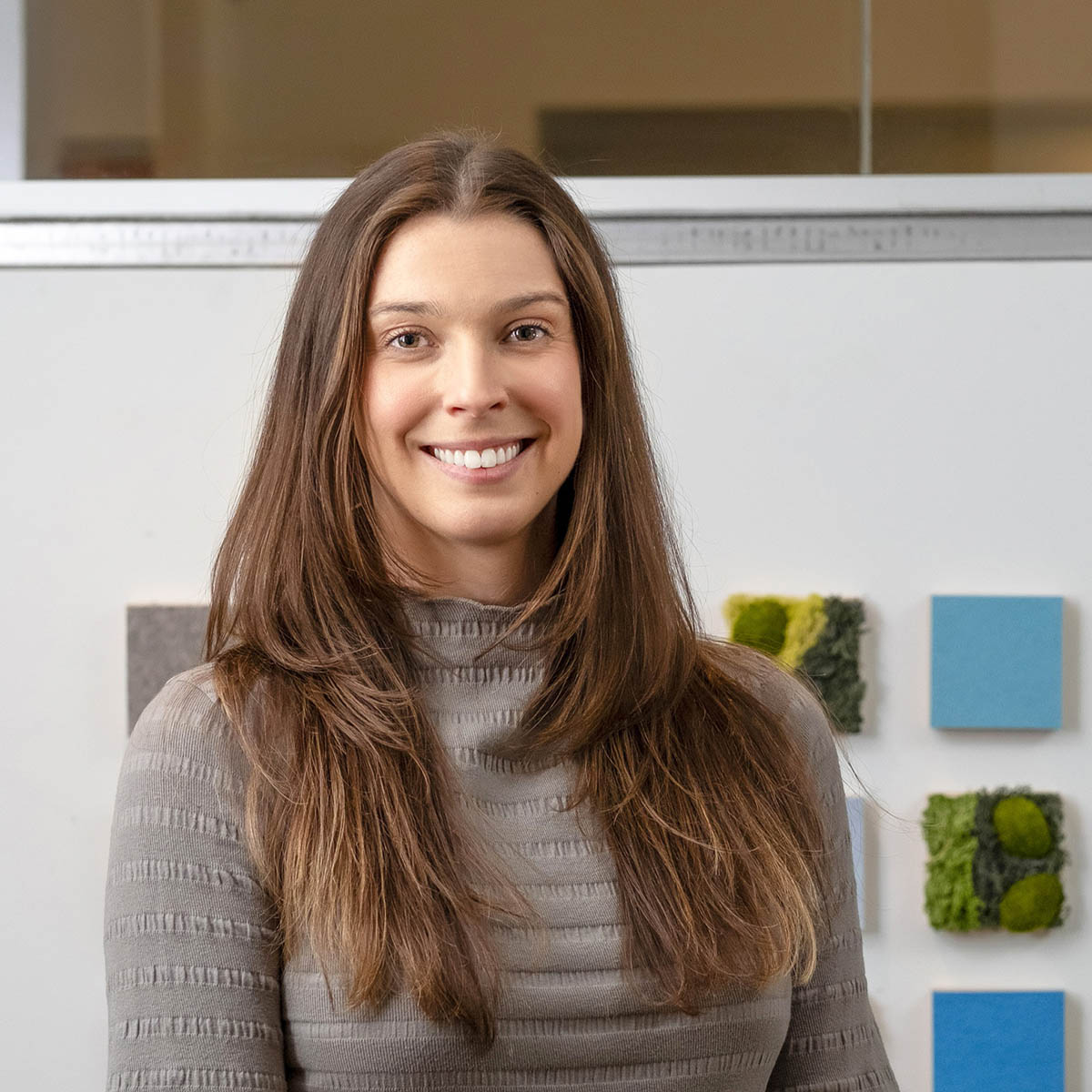 Photo of Abbey Bartkowski, a white woman with brown hair wearing a grey sweater and smiling for a photo